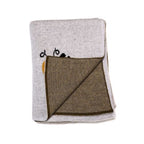 Primer plano de la textura del tejido de punto de la cobija de algodón, mostrando el detalle de una abeja tejida.