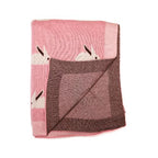 Primer plano de la textura suave del algodón y el detalle de un conejo tejido en la cobija hipoalergénica.