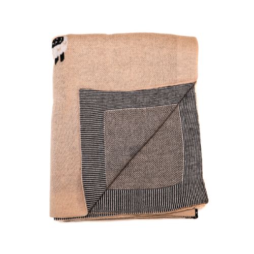 Primer plano detallado de la textura fina y suave del tejido de una manta de alpaca hipoalergénica.